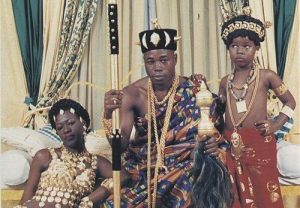 West African royalty king outfit family black man woman child crown scepter animals