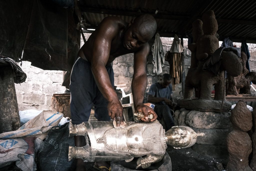 craftsman polishing bronze art benin nigeria museum